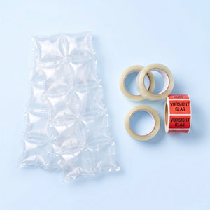 Starter-Set für kleine Versender als Flatlay: Füllmaterial, Klebeband und Warnetiketten übersichtlich nebeneinander